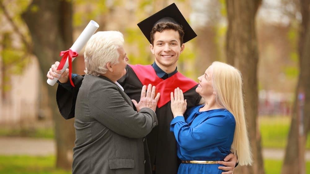 Happy young man with his parents on graduation day